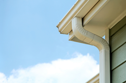 White aluminum gutter and downspout on exterior of a home