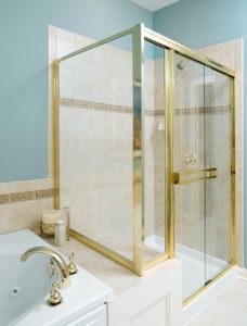 Glass shower enclosure with gold trim