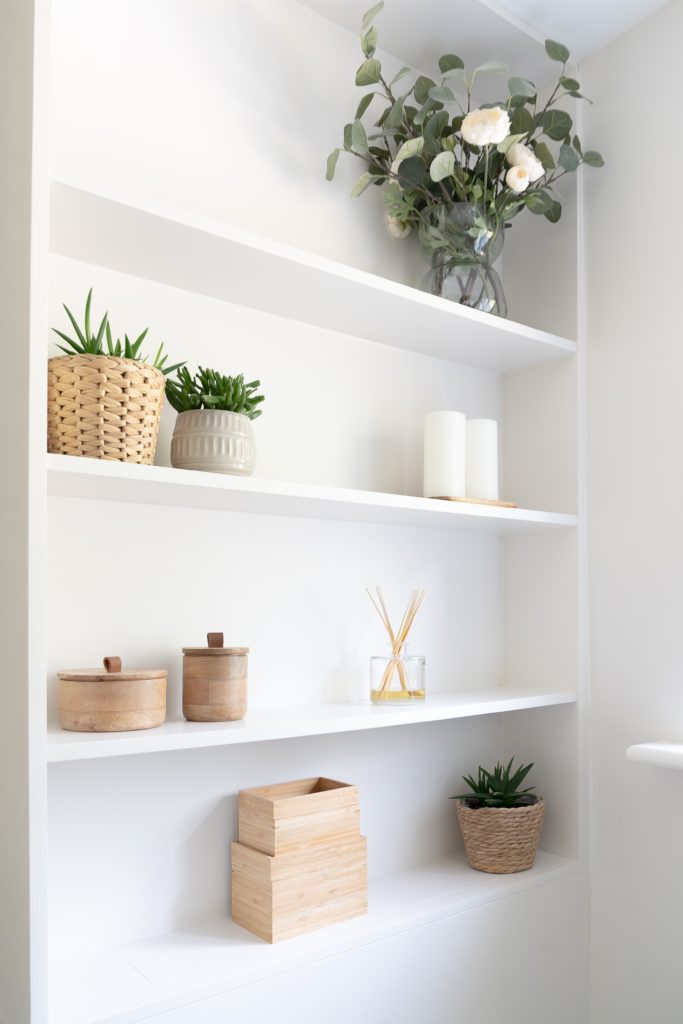 White shelving holding storage and decor items